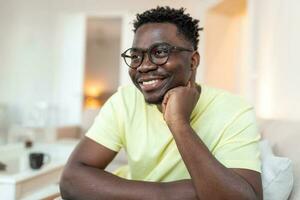 profilo immagine di sorridente giovane africano americano uomo nel bicchieri posa nel proprio casa appartamento. vicino su colpo alla testa ritratto di contento del Millennio birazziale maschio locatario o inquilino nel spettacoli mostrare ottimismo. foto