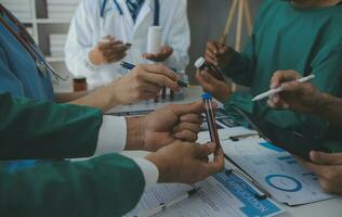 medico tecnologia Rete squadra incontro concetto. medico mano Lavorando inteligente Telefono moderno digitale tavoletta il computer portatile computer grafica grafico interfaccia, sole travi effetto foto