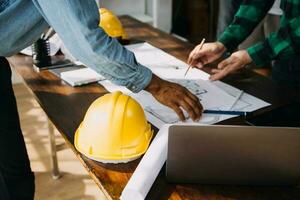 costruzione e struttura concetto di ingegnere Lavorando disegno su planimetria incontro per progetto Lavorando con compagno su modello edificio e ingegneria utensili nel Lavorando luogo, costruzione concetto. foto