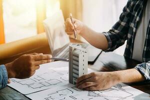 costruzione e struttura concetto di ingegnere Lavorando disegno su planimetria incontro per progetto Lavorando con compagno su modello edificio e ingegneria utensili nel Lavorando luogo, costruzione concetto. foto