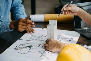 costruzione e struttura concetto di ingegnere Lavorando disegno su planimetria incontro per progetto Lavorando con compagno su modello edificio e ingegneria utensili nel Lavorando luogo, costruzione concetto. foto