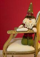 un' ripieno Santa Claus seduta su un' sedia foto