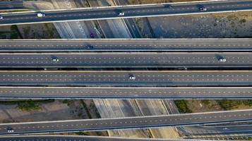 vista aerea dall'alto dell'autostrada, strada di svincolo della città di trasporto con auto sull'incrocio di intersezioni riprese da drone foto