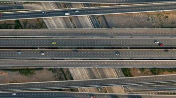 vista aerea dall'alto dell'autostrada, strada di svincolo della città di trasporto con auto sull'incrocio di intersezioni riprese da drone foto