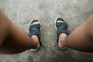 foto di asiatico o orientale maschio piedi indossare sandali