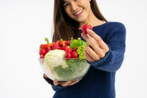 Ritratto di bella donna asiatica sorridente che tiene una ciotola piena di verdure fresche biologiche isolate su sfondo bianco, concetto di alimentazione sana, concetto di nutrizione sana, vegetariano foto