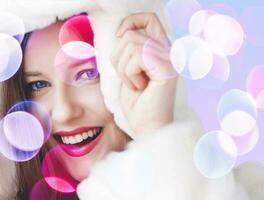 allegro Natale ritratto di sorridente giovane donna indossare soffice bianca pelliccia cappotto, lusso bellezza e contento vacanza foto