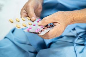 asiatico anziano o anziana signora anziana paziente in possesso di pillole di capsule di antibiotici in confezione blister per il trattamento di infezione paziente in ospedale farmacia farmacia concetto.