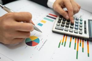 contabile asiatico che lavora e analizza i rapporti finanziari contabilità del progetto con grafico grafico e calcolatrice in ufficio moderno, finanza e concetto di business. foto