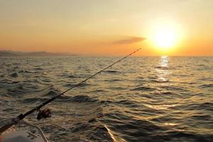 pesca durante il tramonto sull'oceano foto