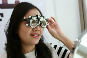 tailandese signora indossare occhiali dentro il clinica, donna nel ottico foto