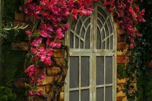 cancello coperto di vegetazione con cespugli per un abbandonato proprietà terriera Casa. vecchio metallo recinzione. ornato arrugginito porta di un' tradizionale vecchio dimora Casa foto