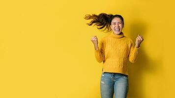 ritratto di una donna asiatica felice che urla un successo eccitato e celebrante isolato su sfondo giallo. avere successo foto