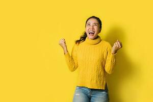 ritratto di una donna asiatica felice che urla un successo eccitato e celebrante isolato su sfondo giallo. avere successo foto
