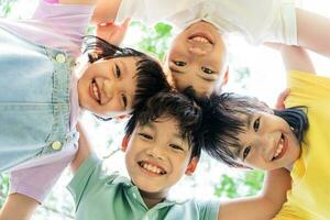 gruppo di carino asiatico bambini avendo divertimento nel il parco foto