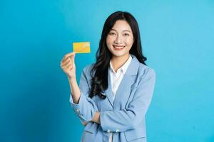 ritratto di giovane asiatico donna d'affari in posa su blu sfondo foto