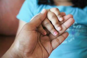 padre che tiene la mano del bambino, primo piano. foto