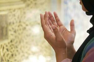 primo piano delle donne musulmane che pregano a mano al ramadan foto