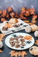 pronto a mangiare Halloween trattare - Pan di zenzero biscotto con cioccolato glassatura su un' piatto su il tavolo con zucche e le foglie. tradizionale celebrazione. verticale Visualizza foto
