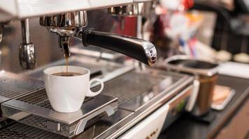 tazza di caffè bianco sul tavolo all'interno del caffè foto