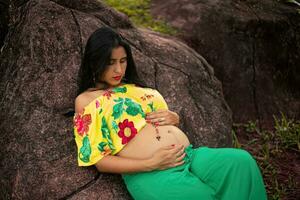 incinta donna in posa nel un' parco foto