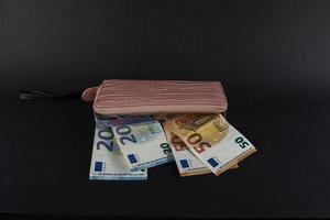 portafoglio da donna sopra le banconote in euro foto