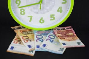banconote in euro sotto un orologio foto