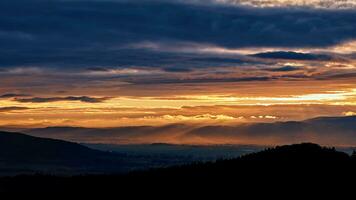 tramonto drammatico cielo al di sopra di montagne forma foto