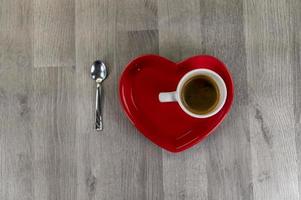 una tazza di caffè con un piattino a forma di cuore foto
