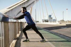 uomo allungamento su un' ponte ringhiera. sport concetto foto