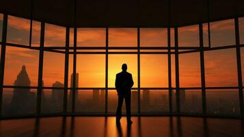 attività commerciale uomo in piedi nel il ufficio guardare su di il finestra a tramonto cielo. ai generativo. foto