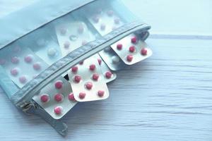 Close up di pillole di blister in una piccola borsa su sfondo blu
