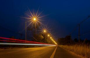 un' Visualizza di arancia esplosioni di stelle a partire dal luci stradali e auto luci passando. foto