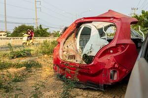 un' posteriore Visualizza di un' rosso auto relitto e altri dire bugie su il terra. foto