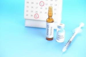 vaccino contro il coronavirus, siringa e calendario sul tavolo