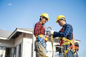 costruzione lavoratore preparazione sicurezza nel opera Abiti prima installazione nuovo coperture utensili coperture Strumenti, elettrico trapani e Usato su nuovo di legno tetti con metallo lenzuola foto