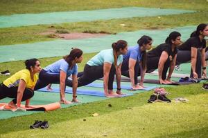 nuovo delhi, India, Maggio 31 2023 - gruppo yoga esercizio classe surya namaskar per persone di diverso età nel lodhi giardino, internazionale yoga giorno, grande gruppo di adulti frequentando un' yoga classe nel parco foto