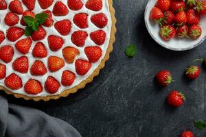 delizioso fragola crostata con frustato crema e mascarpone su un' buio calcestruzzo sfondo. superiore Visualizza. copia spazio. foto