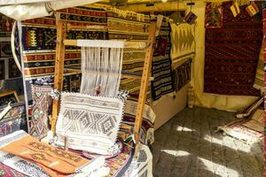 un' tradizionale tappeto essere intrecciata su un' tappeto verticale telaio, mostrando lana mucchio sotto tensione, fondazione, ordito e trama. foto