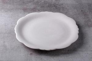 piatto vuoto in ceramica bianca vuota su tavola di cemento foto