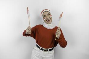 contento sorridente indonesiano musulmano donna indossare rosso superiore e bianca hijab Tenere dell'Indonesia bandiera per celebrare Indonesia indipendenza giorno. isolato di bianca sfondo. foto