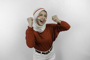 un' giovane asiatico musulmano donna con un' contento riuscito espressione indossare rosso superiore e bianca hijab isolato di bianca sfondo. dell'Indonesia indipendenza giorno concetto. foto