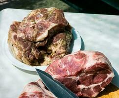 fresco pezzi di Maiale collo su un' di legno cucina tavola e marinato bistecche su un' piatto. pezzi di maiale carne avvicinamento foto