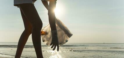 Salva acqua. volontario raccogliere su spazzatura spazzatura a il spiaggia e plastica bottiglie siamo difficile decomporsi impedire danno acquatico vita. terra, ambiente, greening pianeta, ridurre globale riscaldamento, Salva mondo foto