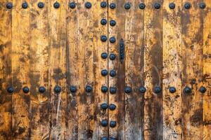 antico di legno porta con metallo rivetti.. astratto strutturato ruvido sfondo. foto