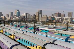 johannesburg, Sud Africa, agosto 13 2018 il centrale parco treno stazione nel centro johannesburg con il città orizzonte nel il sfondo foto