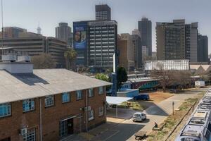 johannesburg, Sud Africa, agosto 13 2018 il centrale parco treno stazione nel centro johannesburg con il città orizzonte nel il sfondo foto