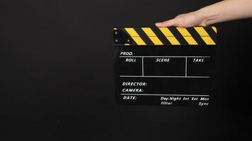 mano è Tenere giallo e nero colore film ardesia.it è Usato nel video produzione e film industria su nero sfondo. foto