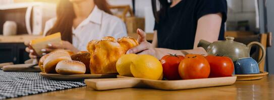 contento Due giovane donne guardare il computer portatile computer durante cucinando insieme nel cucina camera a casa. Due giovane diverso lesbica donne la spesa tempo insieme. lgbt e Genere identità concetto foto