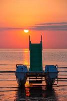 Pedalò sulla spiaggia durante l'incredibile alba sull'oceano a rivazzurra rimini italia foto